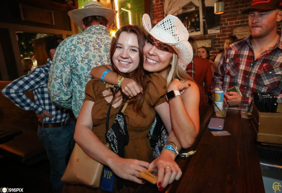 Two girls embracing at the bar